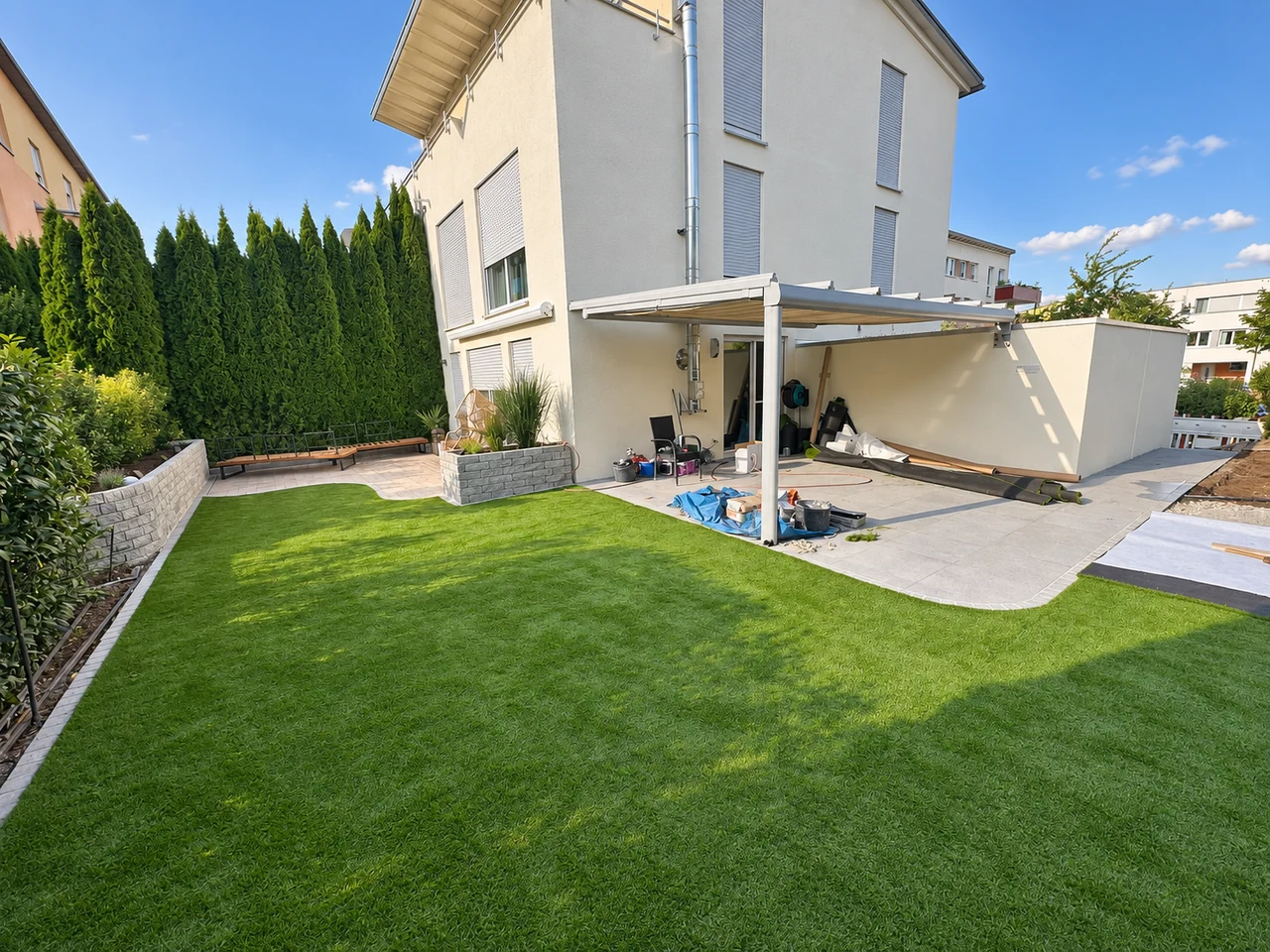 Garten mit Rasenfläche, Terrasse und bepflanzten Beeten